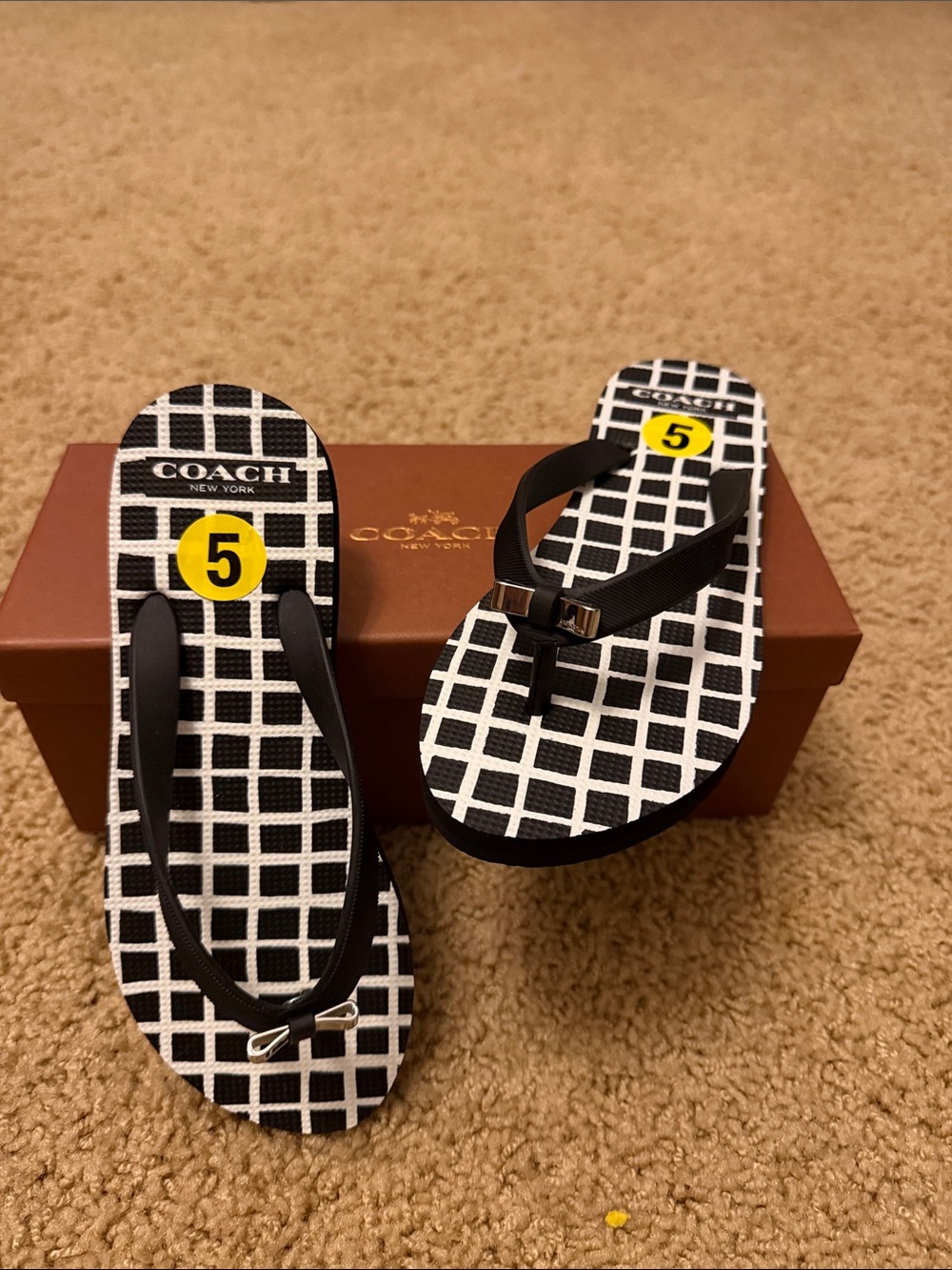 Coach Women’s Black & White Grid Flip Flops with Silver Metal Bow